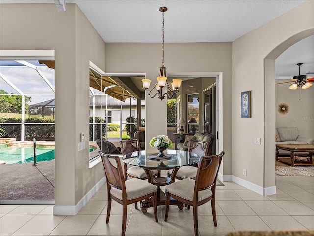 dining space with a sunroom, ceiling fan, light tile patterned floors, and baseboards