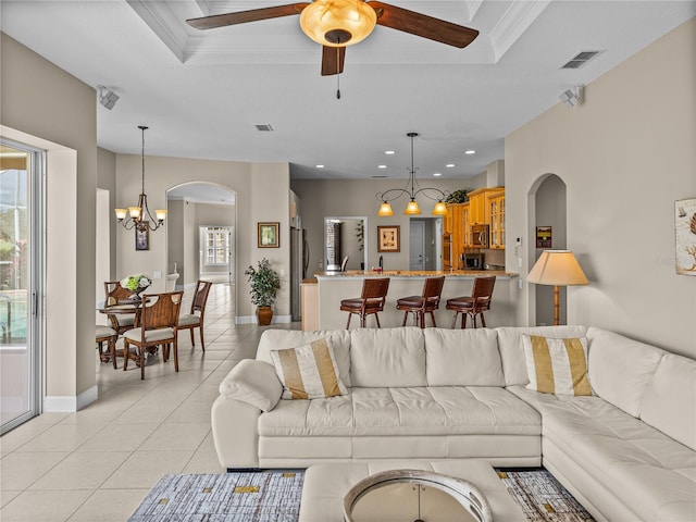 living room featuring a raised ceiling, visible vents, and light tile patterned floors