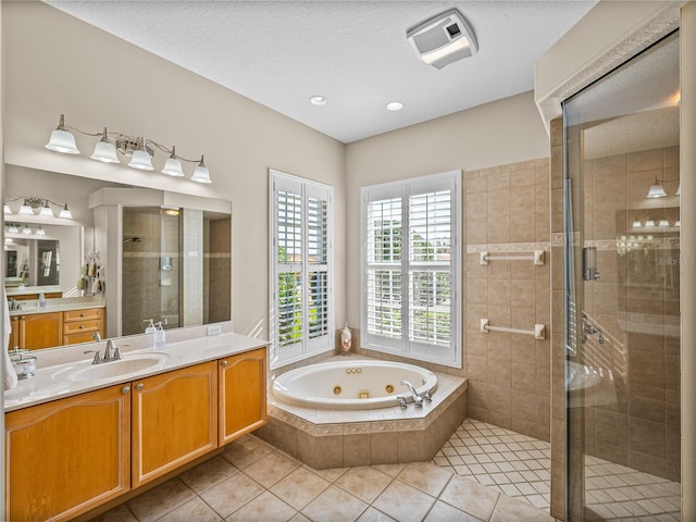 bathroom featuring a stall shower, a textured ceiling, vanity, a tub with jets, and tile patterned floors