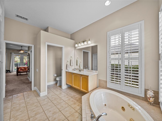 bathroom with visible vents, toilet, tile patterned floors, a jetted tub, and vanity