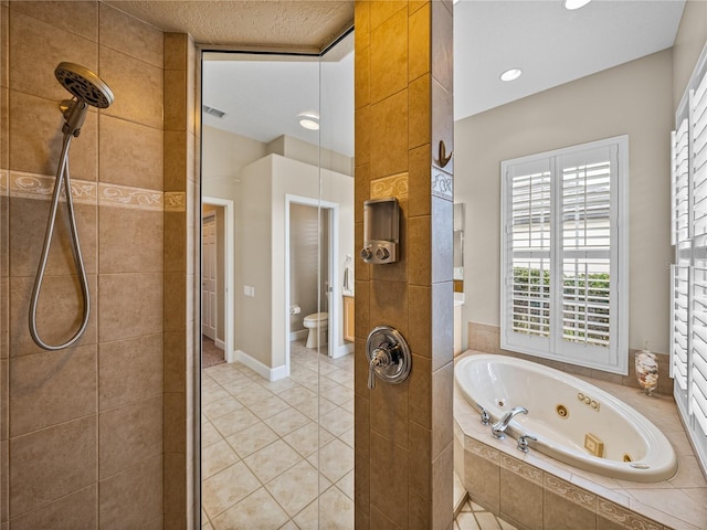 bathroom featuring a textured ceiling, toilet, tiled shower, tile patterned floors, and a tub with jets