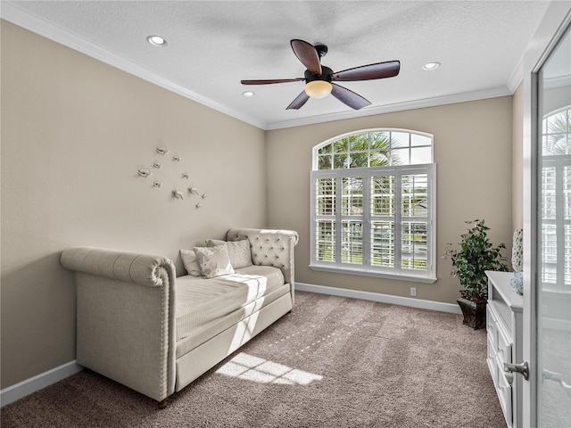 sitting room with baseboards, carpet floors, ornamental molding, and a healthy amount of sunlight