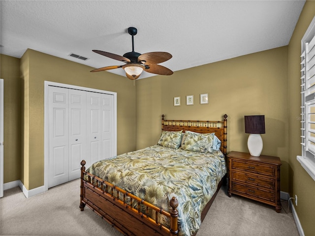 carpeted bedroom featuring baseboards, visible vents, ceiling fan, a textured ceiling, and a closet