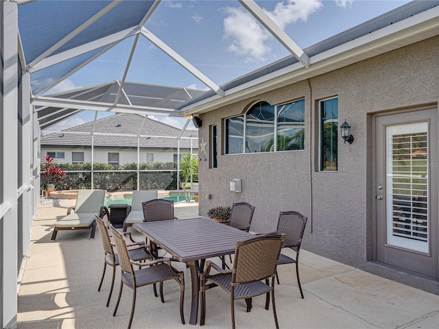 view of patio featuring outdoor dining area, glass enclosure, and an outdoor pool