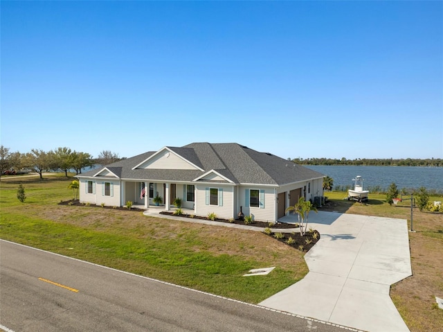 view of front of property featuring a water view, a garage, concrete driveway, and a front yard