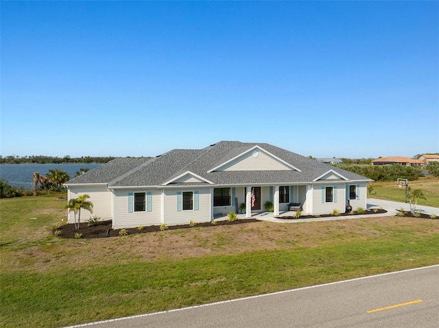 view of front of home featuring a front lawn and a shingled roof