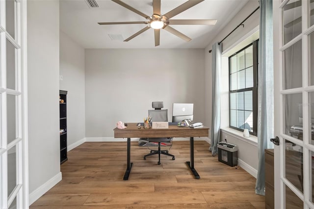 office space with light wood-style floors, ceiling fan, baseboards, and french doors