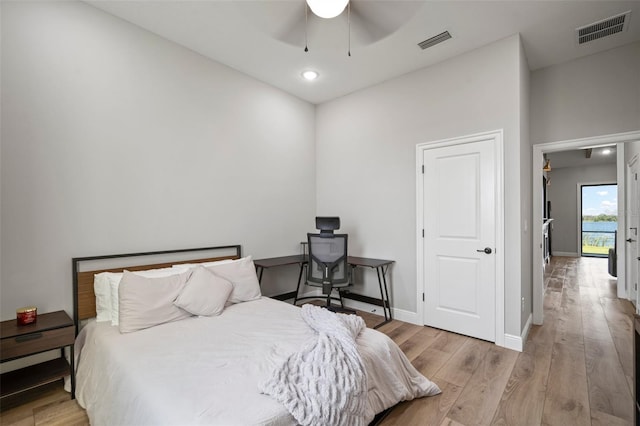 bedroom featuring ceiling fan, light wood-type flooring, visible vents, and baseboards