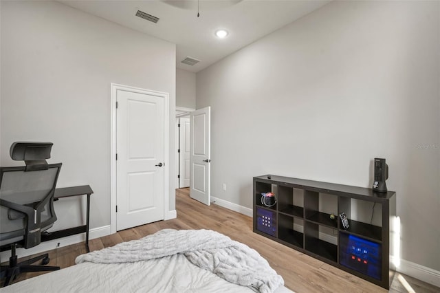 bedroom with visible vents, baseboards, and wood finished floors