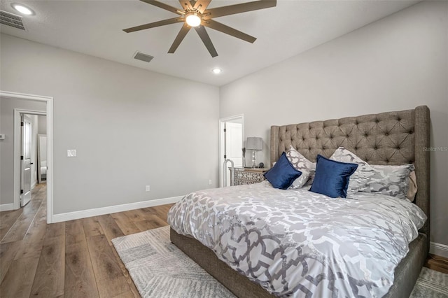 bedroom featuring a ceiling fan, baseboards, visible vents, and hardwood / wood-style floors