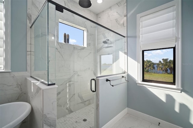 full bathroom featuring a wealth of natural light, marble finish floor, a freestanding bath, and a marble finish shower