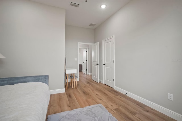 bedroom with light wood-style flooring, visible vents, and baseboards