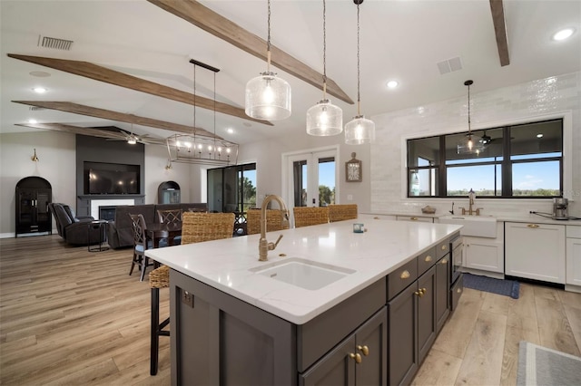 kitchen featuring a glass covered fireplace, a sink, and visible vents