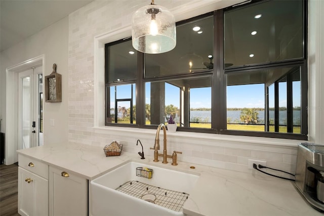 interior space with hanging light fixtures, a sink, and backsplash