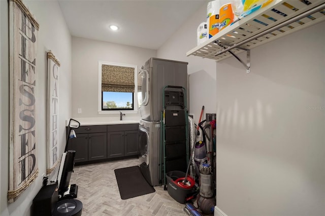 interior space with cabinet space, a sink, stacked washer and clothes dryer, and recessed lighting