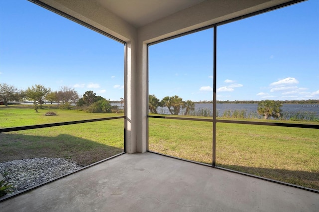 unfurnished sunroom featuring a water view