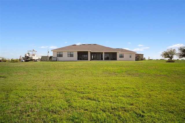 back of house with a yard and stucco siding