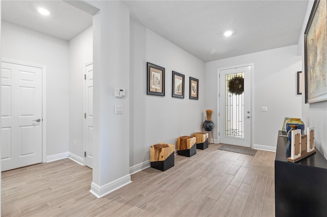 foyer with baseboards, recessed lighting, and light wood-style floors