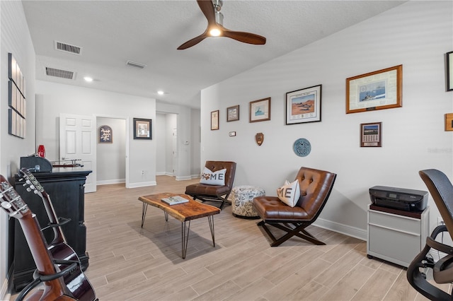 interior space with light wood-style flooring, visible vents, ceiling fan, and baseboards