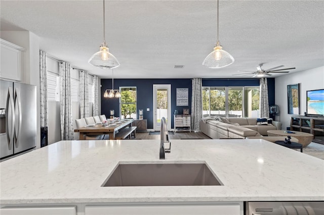 kitchen with stainless steel appliances, a sink, and open floor plan