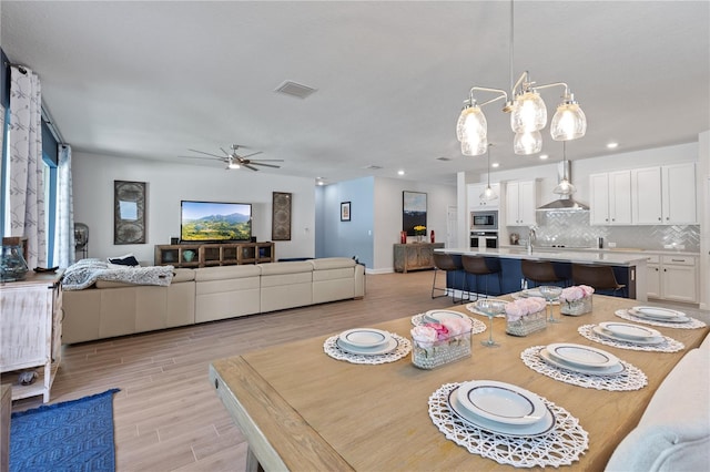 dining room with baseboards, visible vents, a ceiling fan, light wood-style flooring, and recessed lighting