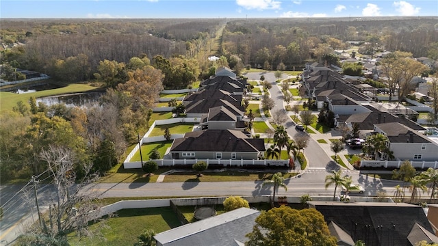 birds eye view of property featuring a forest view, a water view, and a residential view