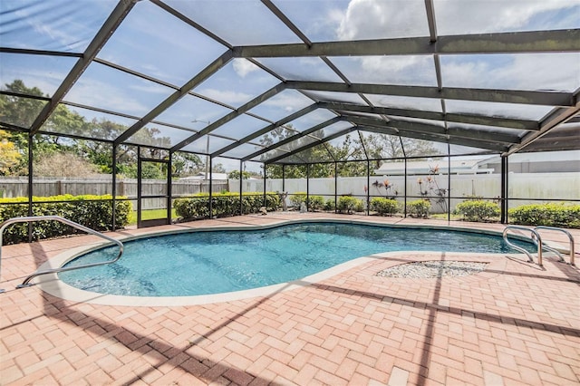 view of pool featuring a fenced in pool, glass enclosure, a fenced backyard, and a patio