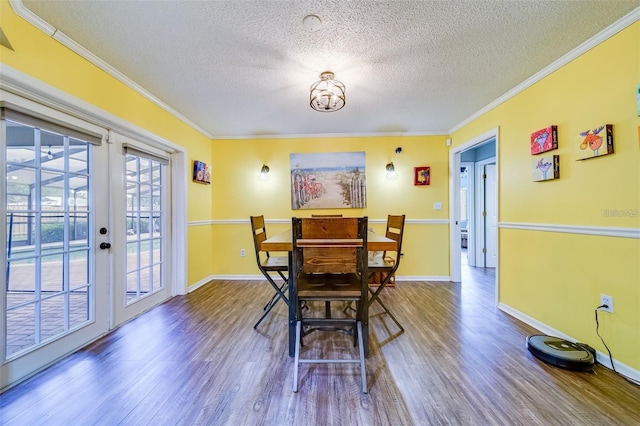 dining area with baseboards, wood finished floors, crown molding, and french doors