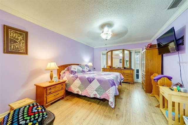 bedroom featuring light wood-style flooring, visible vents, a textured ceiling, and ornamental molding