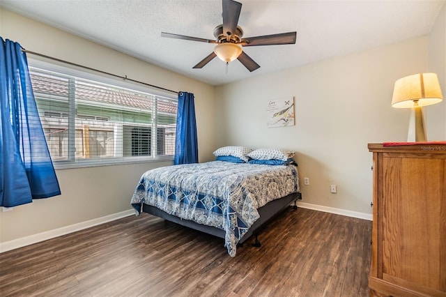 bedroom with a textured ceiling, wood finished floors, and baseboards