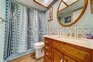 full bathroom with curtained shower, vanity, and toilet