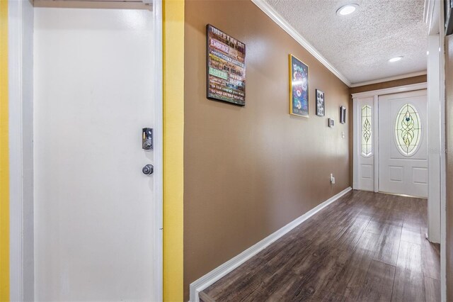 entryway featuring a textured ceiling, recessed lighting, dark wood-type flooring, baseboards, and ornamental molding