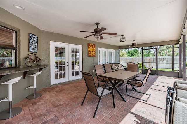 sunroom / solarium featuring ceiling fan and french doors