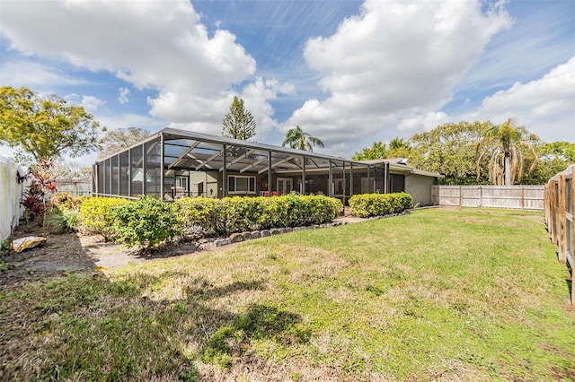 view of yard with glass enclosure and a fenced backyard