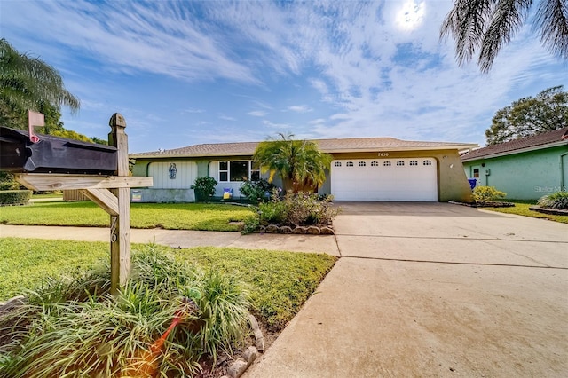 ranch-style home with a front yard, concrete driveway, an attached garage, and stucco siding