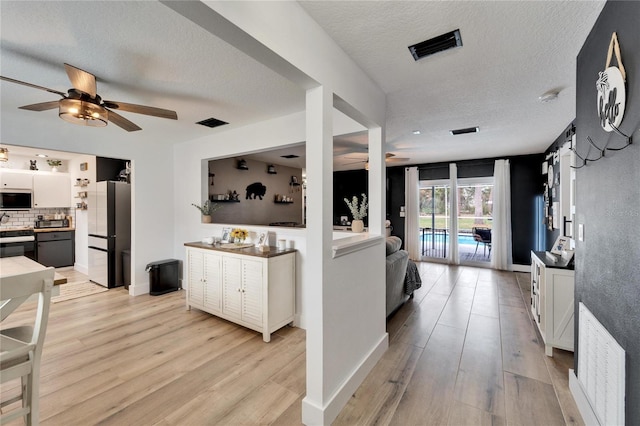 4118 Ramona Dr, Spring Hill, FL 34606 - living room featuring ceiling fan, light wood finished floors, and a textured ceiling