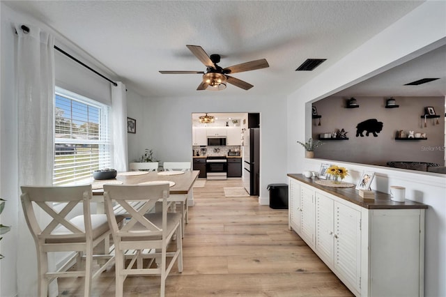 4118 Ramona Dr, Spring Hill, FL 34606 - dining space featuring light wood-style flooring, a ceiling fan, and a textured ceiling