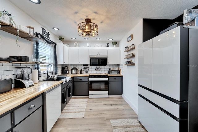4118 Ramona Dr, Spring Hill, FL 34606 - kitchen with stove, freestanding refrigerator, open shelves, black microwave, and recessed lighting