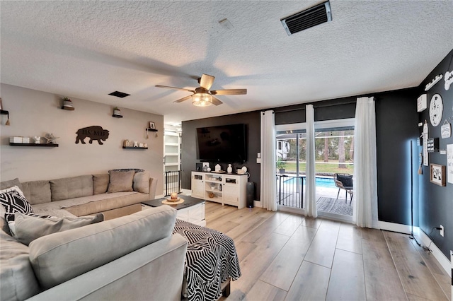 4118 Ramona Dr, Spring Hill, FL 34606 - living room with a ceiling fan, light wood-style floors, and a textured ceiling