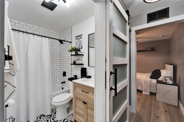4118 Ramona Dr, Spring Hill, FL 34606 - ensuite bathroom featuring a textured ceiling, vanity, shower / bath combo, and wood finished floors