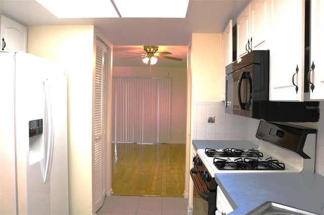 kitchen with white appliances, light tile patterned floors, ceiling fan, white cabinets, and tasteful backsplash