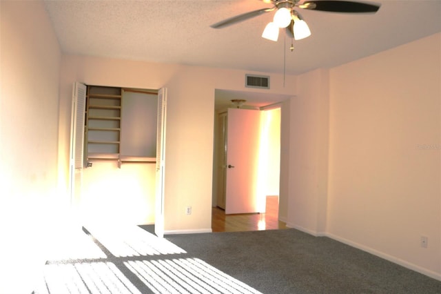 unfurnished bedroom featuring carpet flooring, baseboards, visible vents, and a textured ceiling