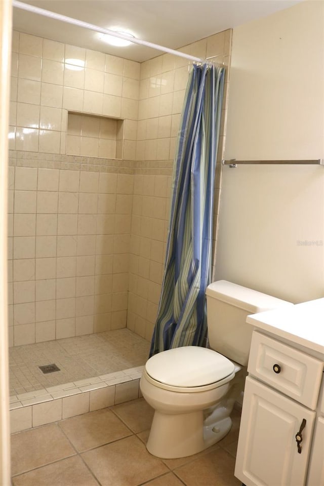 full bathroom with tile patterned flooring, a stall shower, toilet, and vanity