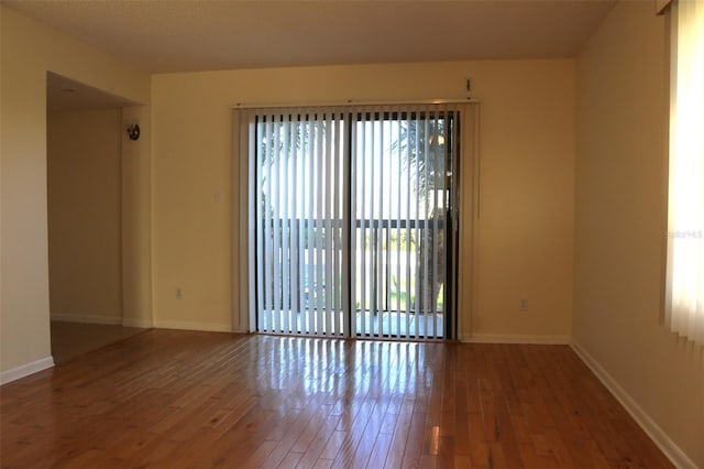 empty room with baseboards and wood-type flooring