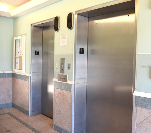 interior space featuring a wainscoted wall and elevator