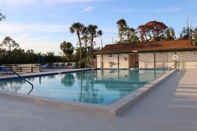 community pool with a patio area and fence