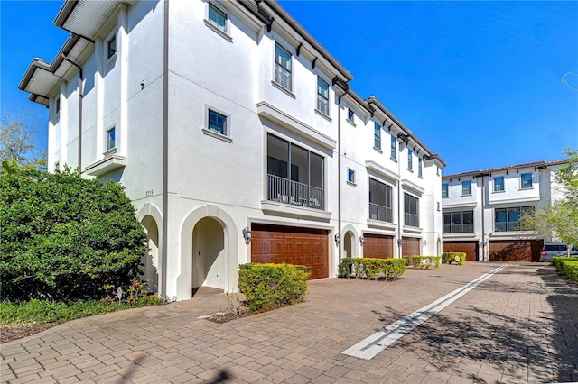 exterior space with an attached garage, a residential view, and decorative driveway