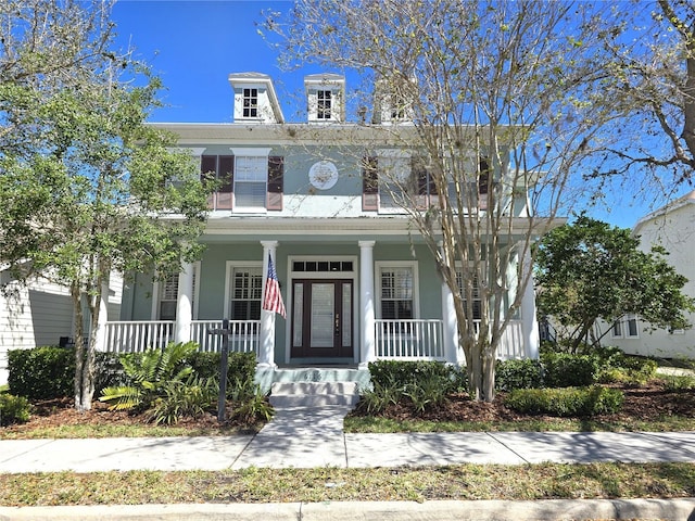 american foursquare style home with a porch and stucco siding