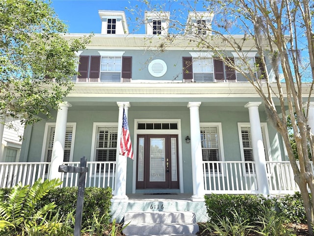 view of front of house featuring covered porch and stucco siding