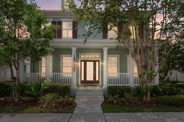 view of front of property featuring covered porch and stucco siding